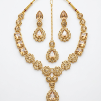Gold plated necklace set with champagne crystals including earrings and maang tikka isolated on white background