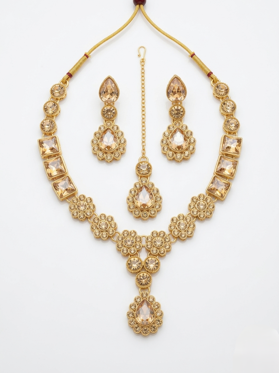 Gold plated necklace set with champagne crystals including earrings and maang tikka isolated on white background