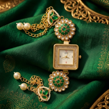 Close-up of Kashmiri designer watch with square dial, green stones and intricate gold detailing