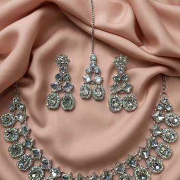 Close-up of silver crystal necklace set with detailed stone work and matching earrings and tikka