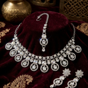 Bridal silver necklace set with sparkling crystal stones on velvet background with earrings and tikka