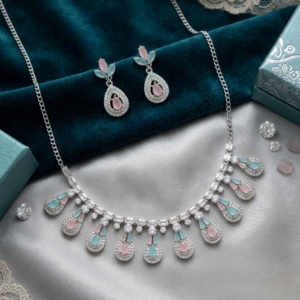 Silver necklace set with pastel mint green and blush pink teardrop stones displayed with matching earrings