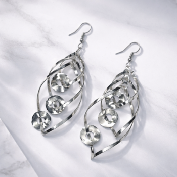 Stylish silver drop earrings with spiral design on marble background, modern fashion earrings