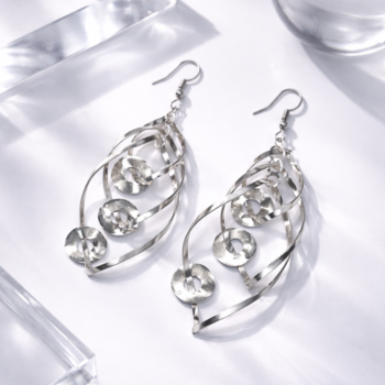 Stylish silver drop earrings with spiral design on marble background, modern fashion earrings
