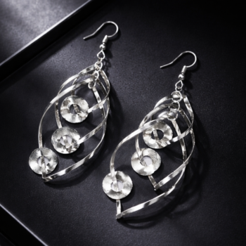 Silver spiral drop earrings with textured circular design on black background, designer earrings for women